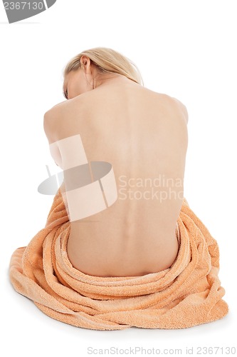 Image of young blonde woman sitting on towel naked back isolated 