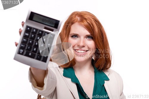 Image of attractive smiling redhead business woman with calculator isolated