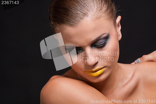 Image of woman with extreme colorfull make up in blue and yellow