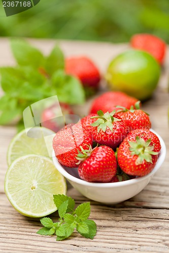 Image of fresh tasty sweet strawberries and green lime outdoor in summer