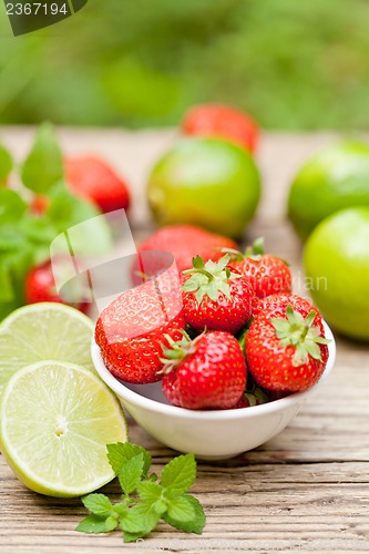 Image of fresh tasty sweet strawberries and green lime outdoor in summer