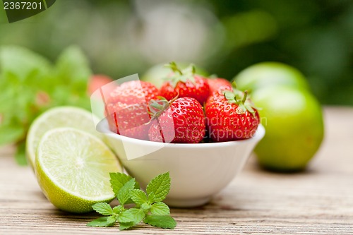Image of fresh tasty sweet strawberries and green lime outdoor in summer