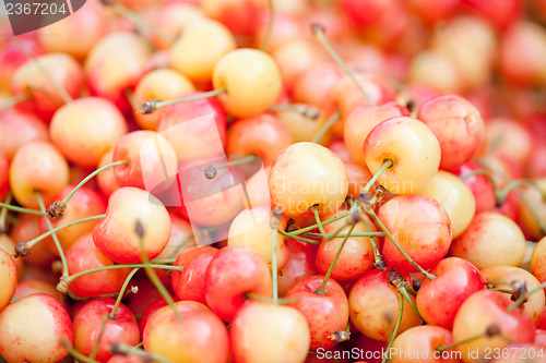 Image of  fresh yellow red sweet cherries macro closeup on market