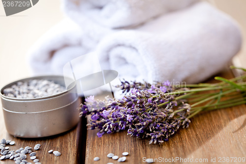 Image of fresh lavender white towel and bath salt on wooden background