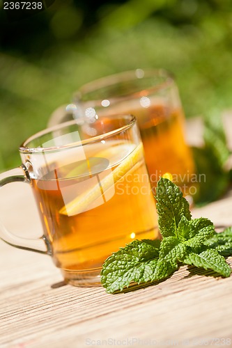 Image of fresh tasty hot tea lemon and mint outdoor in summer 