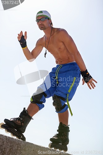 Image of young man with inline skates in summer outdoor 