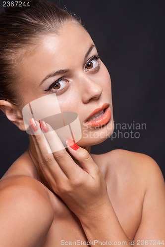 Image of beautiful young woman with orange lipstick and brown eyes 