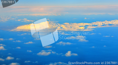 Image of aerial view of mountains and clouds on top