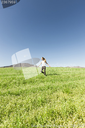 Image of Teenage girl running in meadow