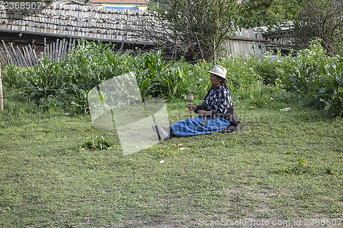 Image of  Tibetan woman and prayer wheel