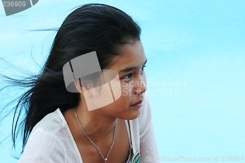 Image of Happy girl relaxing by the swimming pool