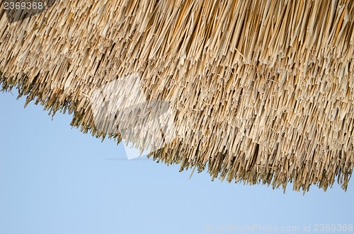 Image of retro organic straw house roof blue sky background 