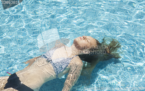 Image of Teenage girl relaxing in the pool