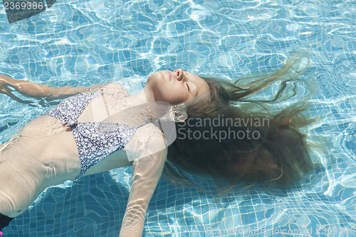Image of Teenage girl relaxing in the pool