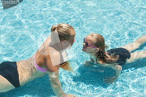 Image of Two girls playing in the pool