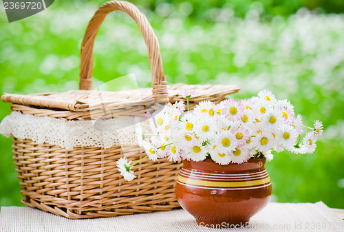 Image of A bouquet of daisies in a pot on the table for a picnic  