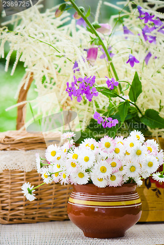 Image of Bouquet of wild flowers in a pot at the table  