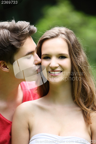 Image of Teenage boy kissing his pretty girlfriend