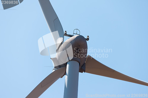 Image of Wind electric generator against blue sky background