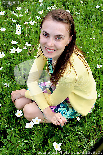 Image of Young beautiful woman on a background of flowers