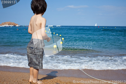 Image of boy looking at the blue sea