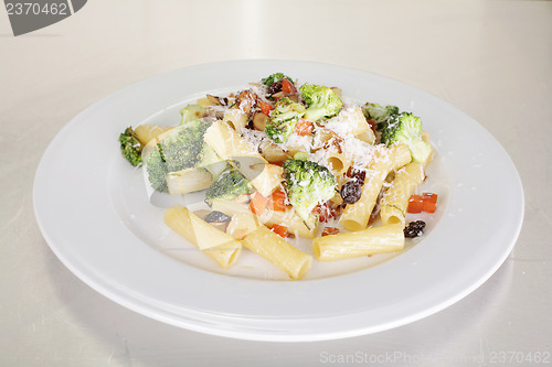 Image of Rigatoni with vegetables served on a white plate. 
