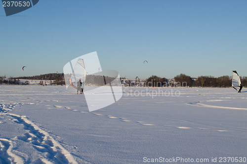 Image of people ice sail surf  kiteboard snow lake  winter 
