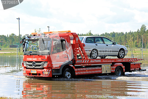 Image of Tow Truck Rescuing Car From Flood