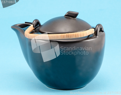Image of black retro teapot blue background 