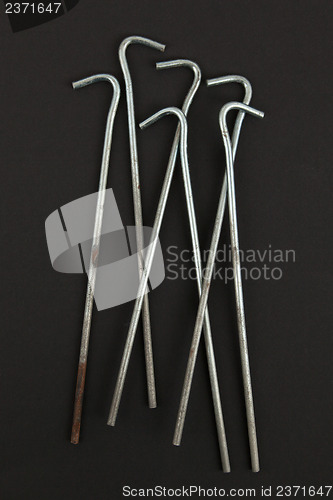 Image of Seven round metal tent pegs