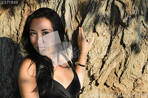 Image of The girl near a tree trunk