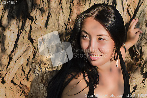 Image of The girl near a tree trunk