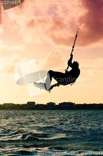 Image of Silhouette of a kitesurfer flying