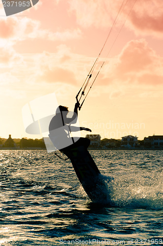 Image of Silhouette of a kitesurfer flying