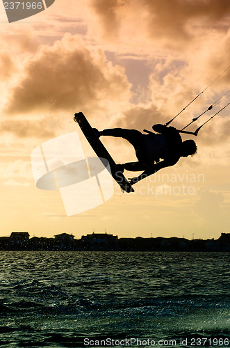 Image of Silhouette of a kitesurfer flying
