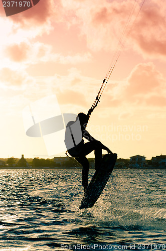 Image of Silhouette of a kitesurfer flying