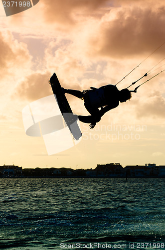 Image of Silhouette of a kitesurfer flying