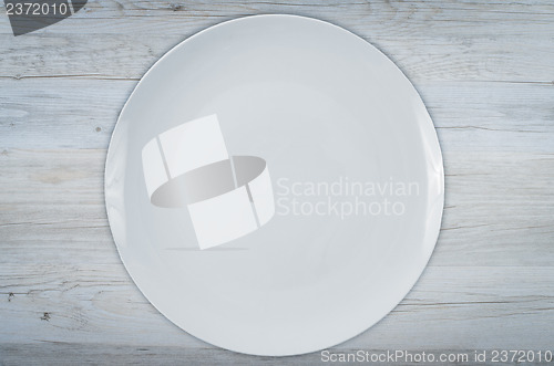 Image of Empty white plate on wooden table 