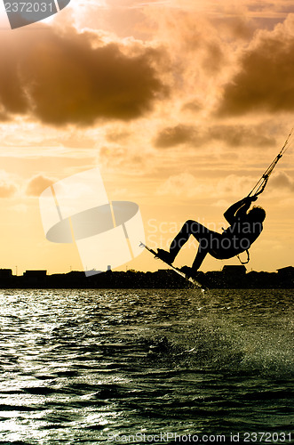 Image of Silhouette of a kitesurfer flying