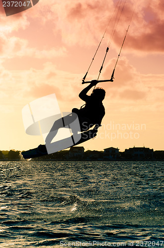 Image of Silhouette of a kitesurfer flying