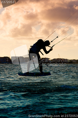 Image of Silhouette of a kitesurfer flying