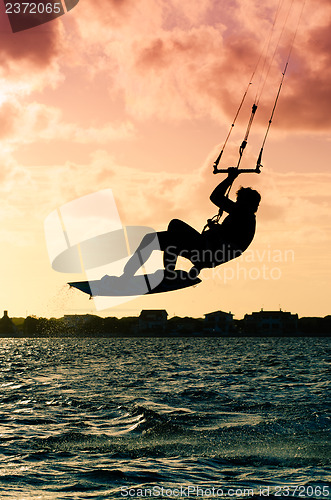 Image of Silhouette of a kitesurfer flying