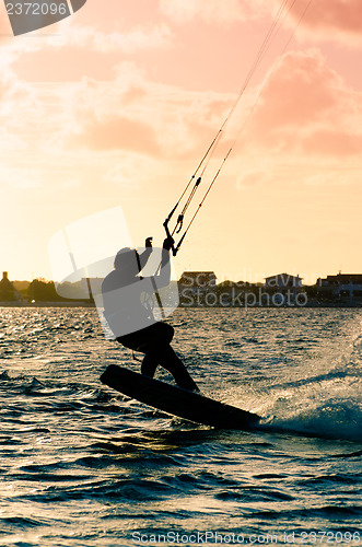 Image of Silhouette of a kitesurfer flying