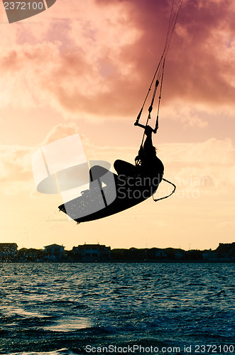 Image of Silhouette of a kitesurfer flying