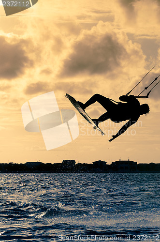 Image of Silhouette of a kitesurfer flying