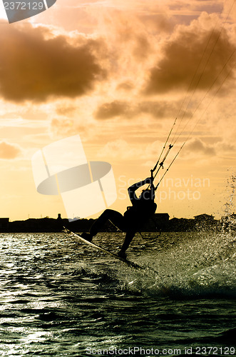 Image of Silhouette of a kitesurfer flying