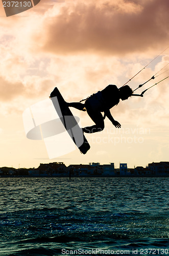 Image of Silhouette of a kitesurfer flying