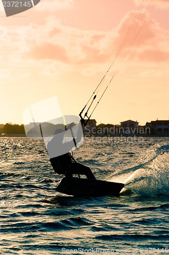 Image of Silhouette of a kitesurfer flying