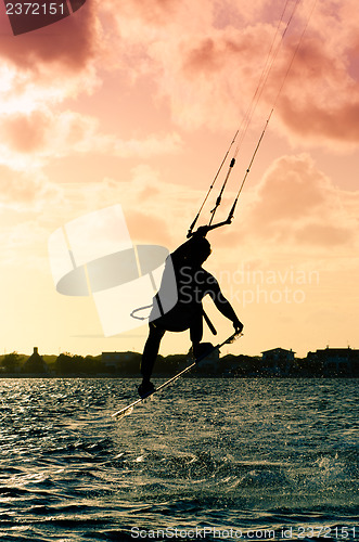 Image of Silhouette of a kitesurfer flying