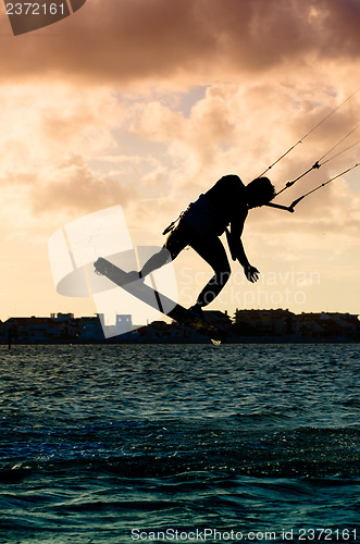 Image of Silhouette of a kitesurfer flying